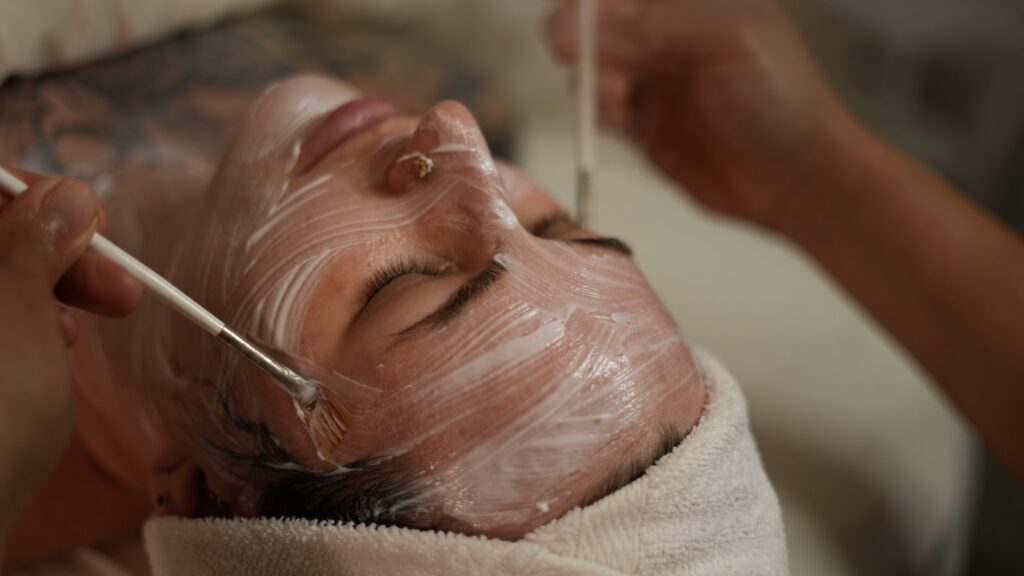Close-up of a woman receiving a medical facial peel as the brushes go down her face.