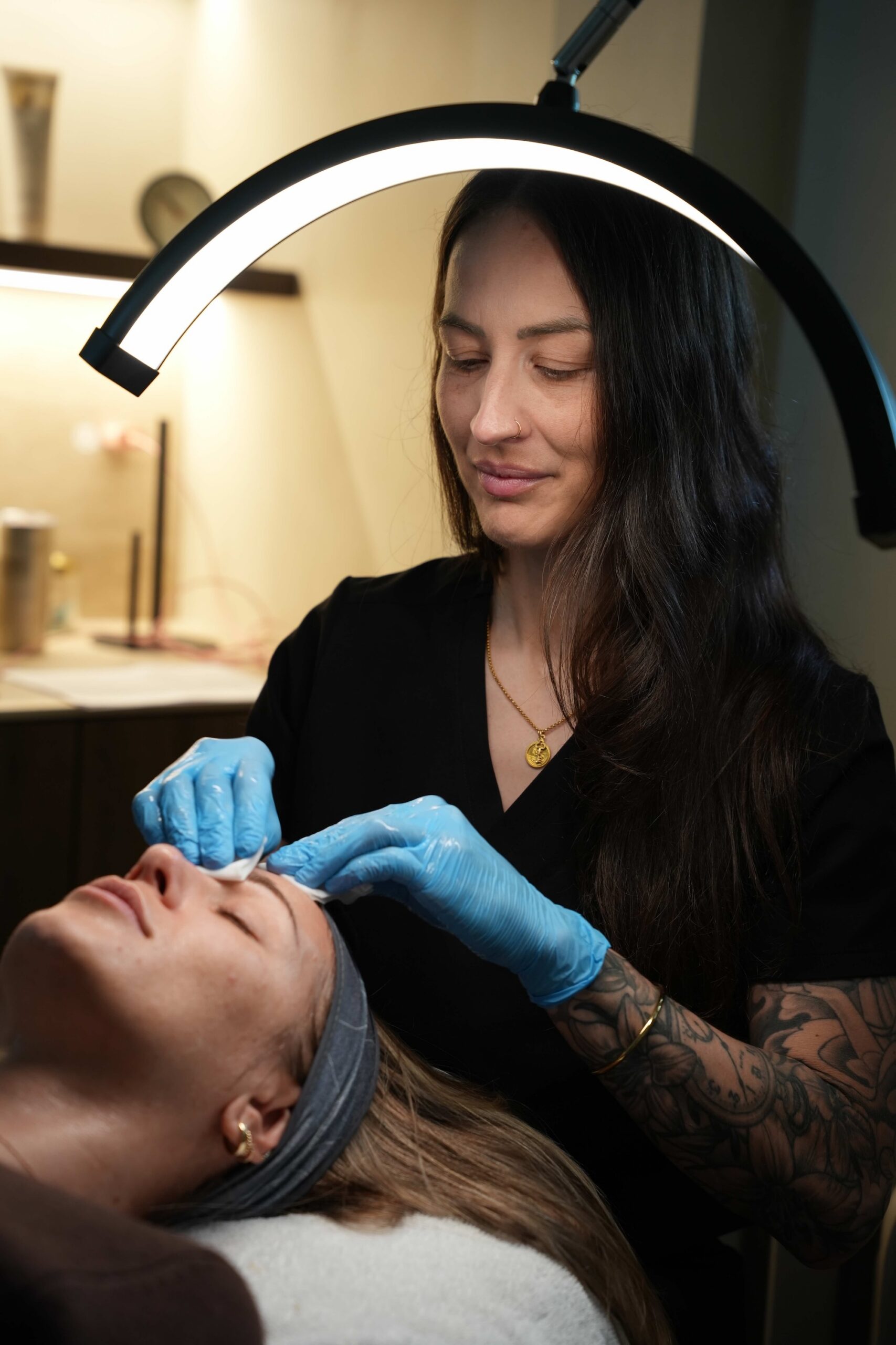 A medical aesthetician prepares a facial peel for a patient.